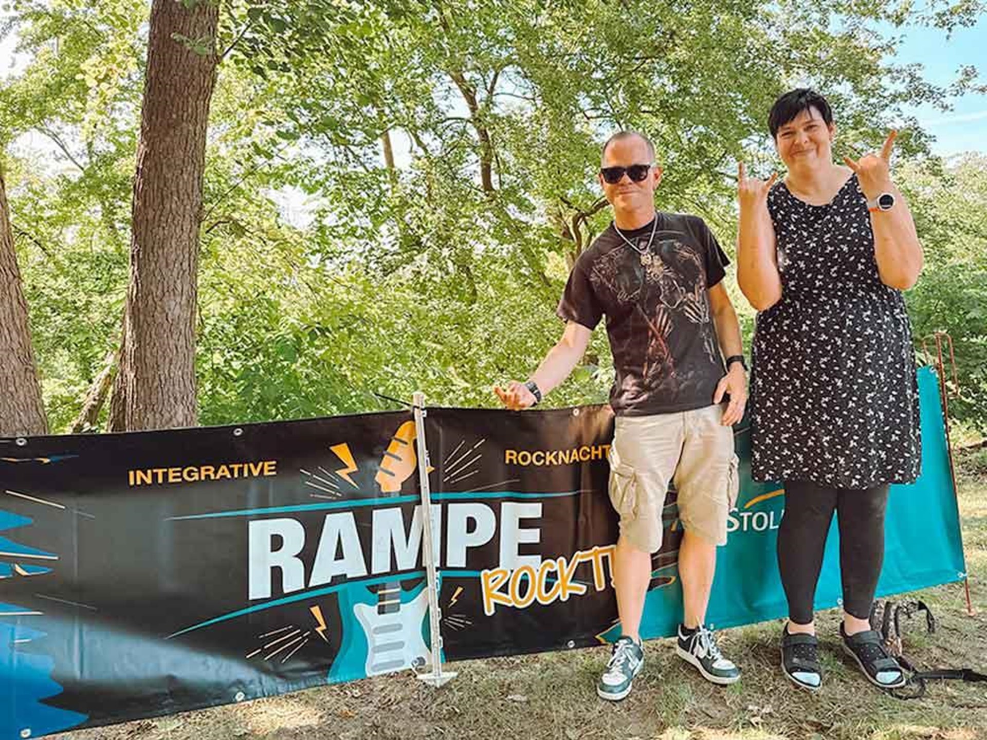 Zwei Personen stehen neben dem Rampe-Rock-Banner.
