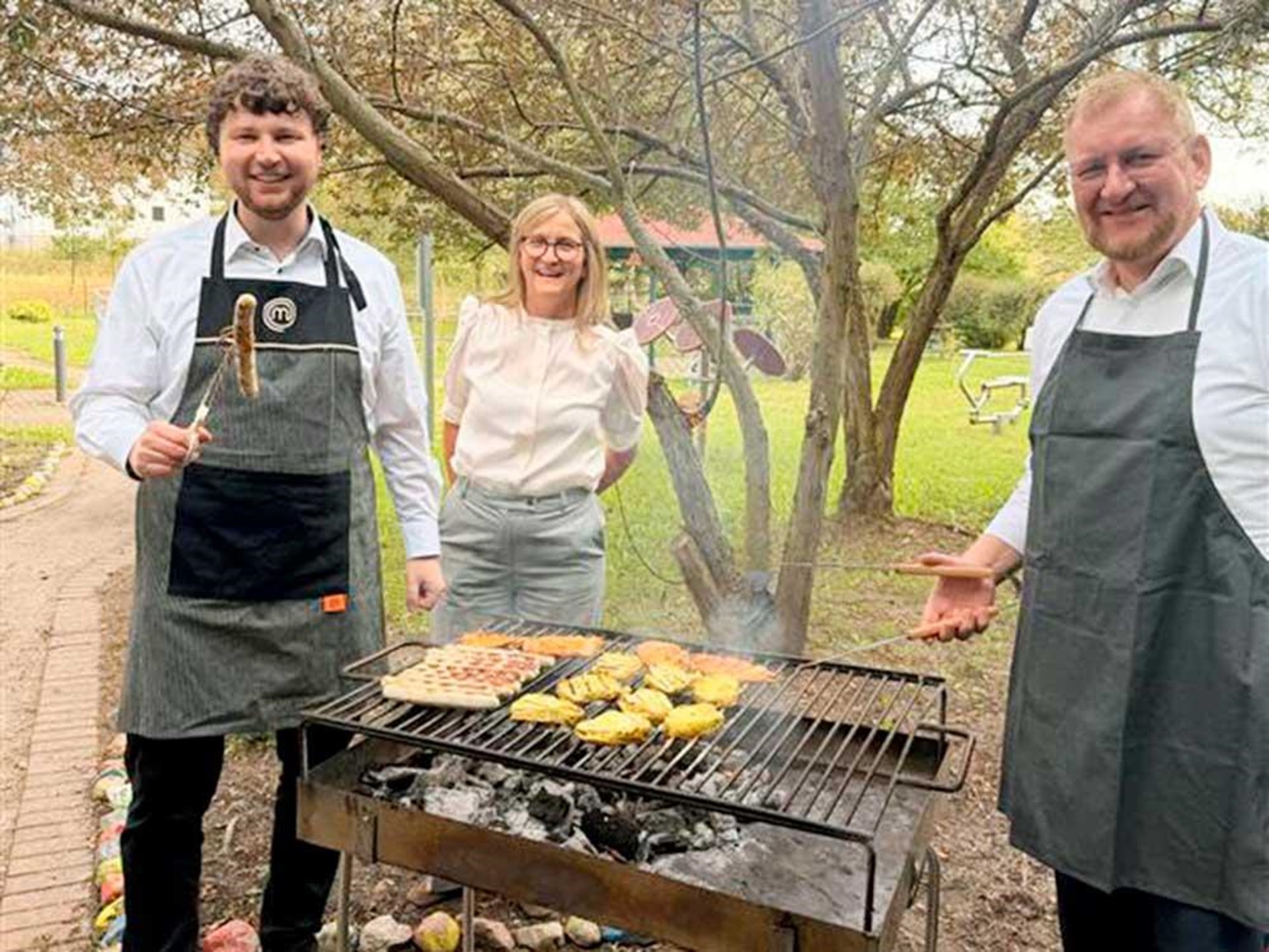 Diözesancaritasdirektor Matthias Timmermann, Einrichtungsleiterin Yvonne Dahl und Lars Krychowski Leiter Geschäftsbereich Altenhilfe stehen zusammen am Grill.