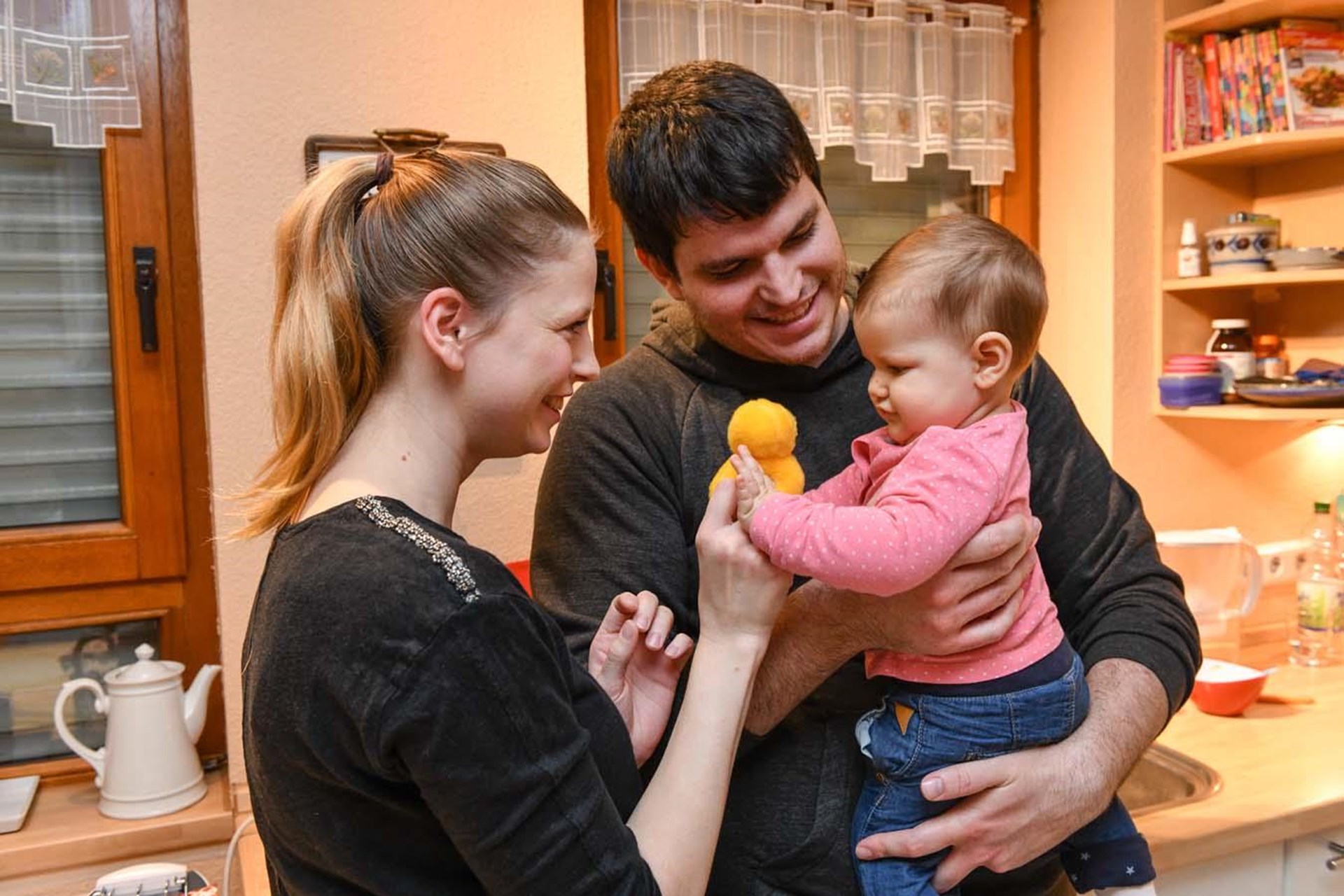 Junge Eltern spielen mit ihrem Baby