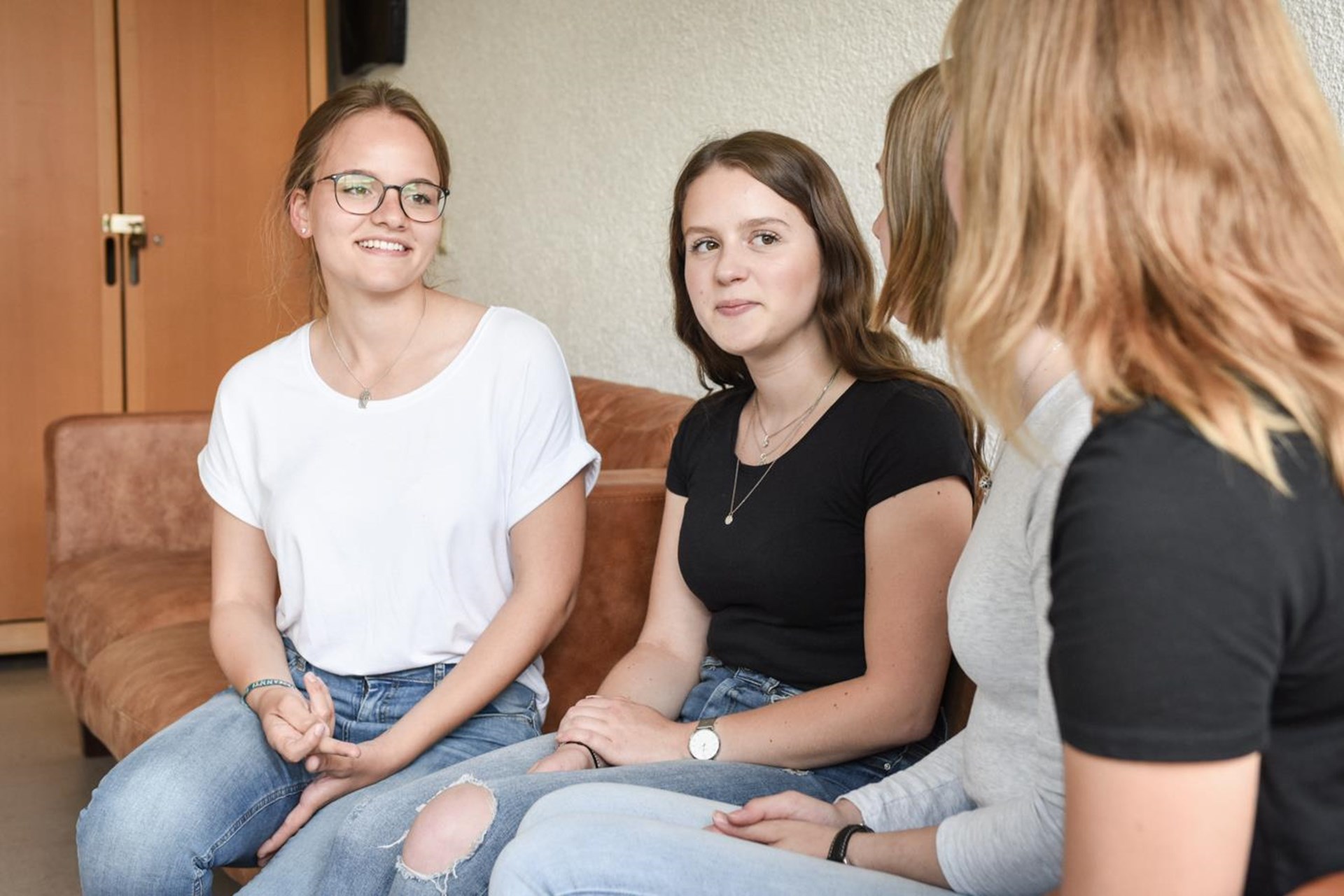 Vier junge Frauen besprechen sich sitzend