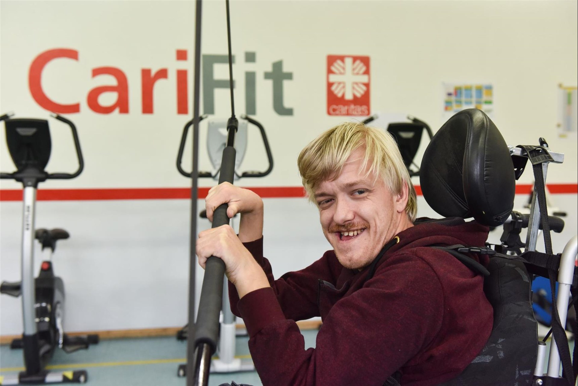 Mann im Rollstuhl trainiert im Gymnastikraum
